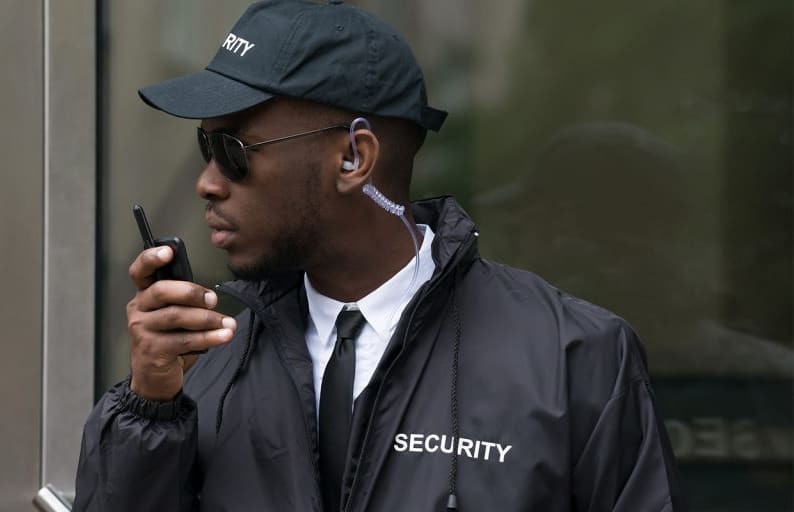 Uniformed security officer communicating on a two-way radio