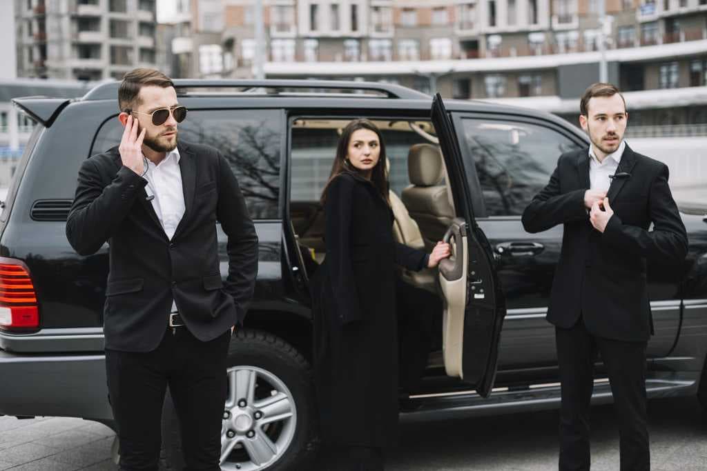 Close protection officers escorting a client from a vehicle